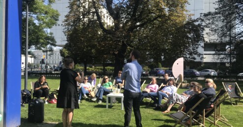 Die deutsch-polnische Projektgruppe von "Culture without barriers" bei einer Präsentation von Mitarbeiter*innen der Nationalgalerie Zachęta, Warschau, auf dem Vorplatz des Museums im Sommer 2022