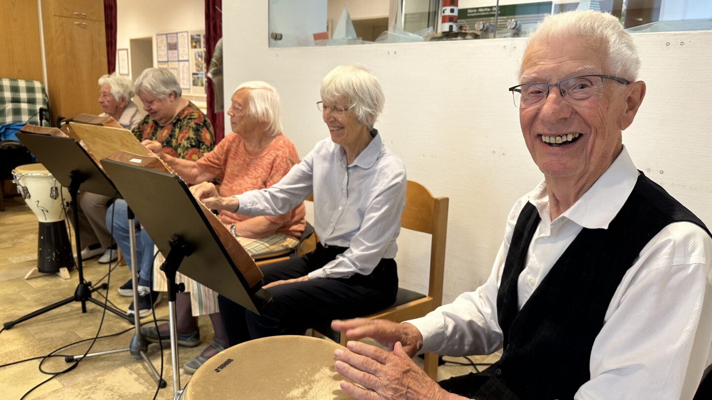 Eine Gruppe von älteren Leuten, die auf Stühlen sitzen und Musik machen